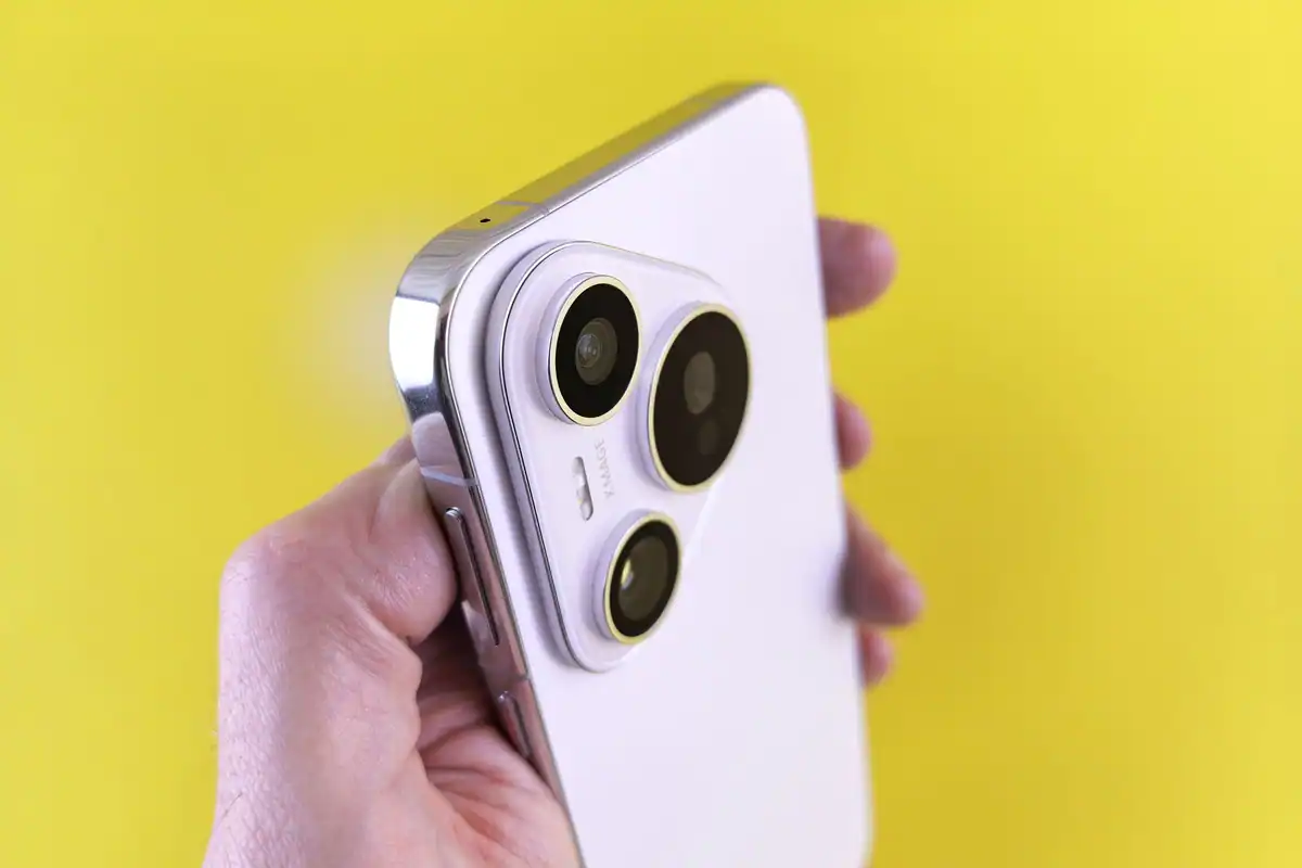 Telefon violet ținut în mână, cu trei obiective foto mari pe spate